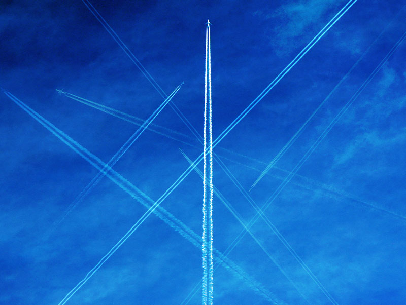 Jet flying overhead leaving contrail in wake of blue sky